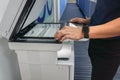 Businessman hand use touchscreen of printer for printing setting in office