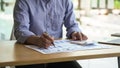 Close up businessman hand using calculator at working desk, financial paper charts and graph