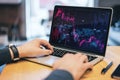 Close up of businessman hand using laptop computer with downward purple forex chart at blurry office desktop. Crisis and recession Royalty Free Stock Photo