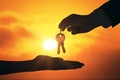 Close up of businessman handing keys on backlit sky and clouds background. Housing, investment and purchase concept