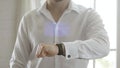 Close up of businessman hands checking life datas on smart watch with hologram.