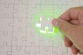 Close up of businessman hands connecting puzzle element and making jigsaw complete. Puzzle jigsaw with green light. Royalty Free Stock Photo