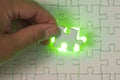 Close up of businessman hands connecting puzzle element and making jigsaw complete. Puzzle jigsaw with green light. Royalty Free Stock Photo