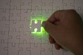 Close up of businessman hands connecting puzzle element and making jigsaw complete. Puzzle jigsaw with green light. Royalty Free Stock Photo