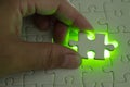 Close up of businessman hands connecting puzzle element and making jigsaw complete. Puzzle jigsaw with green light. Royalty Free Stock Photo