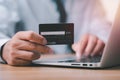 Close up of businessman hands holding a credit card and making a purchase using a laptop