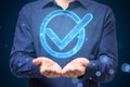 Close up of businessman hands holding glowing blue polygonal checkmark on dark blurry background. Success, business agreement, ok Royalty Free Stock Photo