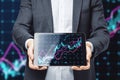 Close up of businessman hands holding tablet with glowing forex index chart with grid on dark background. Market, finance and Royalty Free Stock Photo