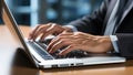 Close-up of businessman hands typing on laptop keyboard at desk in office Royalty Free Stock Photo