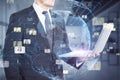 Close up of businessman hands using laptop with creative glowing blue globe hologram with faces on blurry office interior