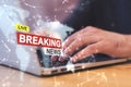 Close up of businessman hands using laptop with creative polygonal hi-tech breaking news hologram on blurry background. Television