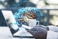 Close up of businessman hands using laptop and smartphone with creative brain hologram on blurry background. Science, future, Royalty Free Stock Photo