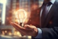 Close up of businessman holding glowing light bulb in palm. Idea concept, Businessman on blurred background using glowing Royalty Free Stock Photo
