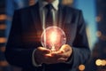 Close up of businessman holding glowing light bulb in palm. Idea concept, Businessman, set against a blurred background, Royalty Free Stock Photo