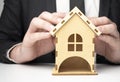 Close-up of businessman holding house model in hands. Mortgage, loan, rent, real estate purchase Royalty Free Stock Photo