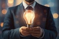 Close up of businessman holding light bulb in his hand. Idea concept, Businessman, set against a blurred background, manipulating Royalty Free Stock Photo