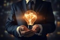 Close up of businessman holding in palm glowing light bulb. Idea concept, Businessman on blurred background using glowing Royalty Free Stock Photo