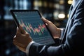 Close up of businessman holding tablet with candlestick chart on screen, Businessman hand close up using tablet with stock market