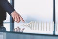 businessman pushing dominoes standing in a row.