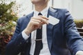 Close up of businessman putting blank business card in his blue jacket pocket. Royalty Free Stock Photo