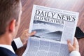 Close-up of businessman reading weather news