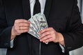 close-up of businessman& x27;s hand in branded suit holding dollar banknotes. Royalty Free Stock Photo