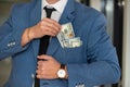 close-up of businessman& x27;s hand in branded suit holding dollar banknotes. Royalty Free Stock Photo