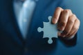 Close-up of Businessman's Hand Holding a Single Puzzle Piece on Blue Background Royalty Free Stock Photo