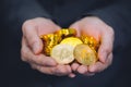 Close-up of businessman`s hands full of bitcoin sign of coins - cryptocurrency financial trade wealth and business investment