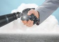 Close-up of businessman shaking hands with robot hand with clouds in background Royalty Free Stock Photo