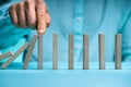 Close-up Of Businessman Stopping The Effect Of Domino With Hand Royalty Free Stock Photo