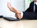 Young Asian businessman pain while using notebook computer in office Royalty Free Stock Photo