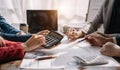 Close up of businessman team working on calculator to calculate financial data report, accountancy document and laptop computer at Royalty Free Stock Photo