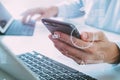 close up of businessman using mobile phone and laptop computer o