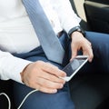 Close up of businessman using mobile smart phone in a car. Royalty Free Stock Photo