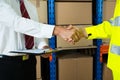 Close-up Of Businessman And Warehouse Worker Shaking Hands