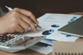 Close up Businessman wear white shirt using pen for checking business growth up or stock market with data statistics level up of Royalty Free Stock Photo