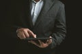 Close-up businessman wearing a black suit holding a tablet Royalty Free Stock Photo