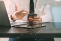 Close up of businessman working with mobile phone on wooden desk in modern office with virtual icon diagram