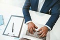 Close up of businessman workingon laptop while sitting in modern coworking