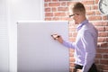 Businessman Writing On Grid Flip Chart Royalty Free Stock Photo