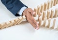 Close up of businessmans hand stopping the domino effect Royalty Free Stock Photo