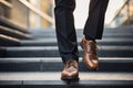 Close up of a businessmans legs ascending stairs, symbolizing confidence and business growth