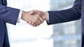 Close-up of Businessmen Shaking there Hands against Boardroom Window