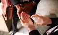 Close Up Of Businesspeople Spraying Hands With Sanitiser During Health Pandemic