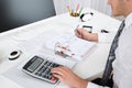 Businessperson Calculating Budget At Desk