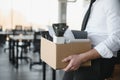 Close-up Of A Businessperson Carrying Cardboard Box During Office Meeting Royalty Free Stock Photo