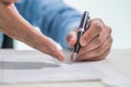 Close up of Businessperson pointing and signing contract about insurance for buying house. Man writing with pen sign of agreements Royalty Free Stock Photo