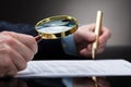 Businessperson Checking Contract Form Through Magnifying Glass Royalty Free Stock Photo