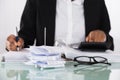 Close-up Of Businesswoman Calculating Tax On Desk Royalty Free Stock Photo